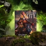 Shattered City front cover on a mossy rock with foliage and green lighting ©SHAW STUDIO