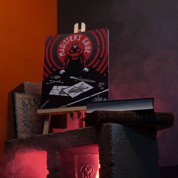 Magister’s Guide for Spire on a cinder block with books and red lighting © SHAW STUDIO